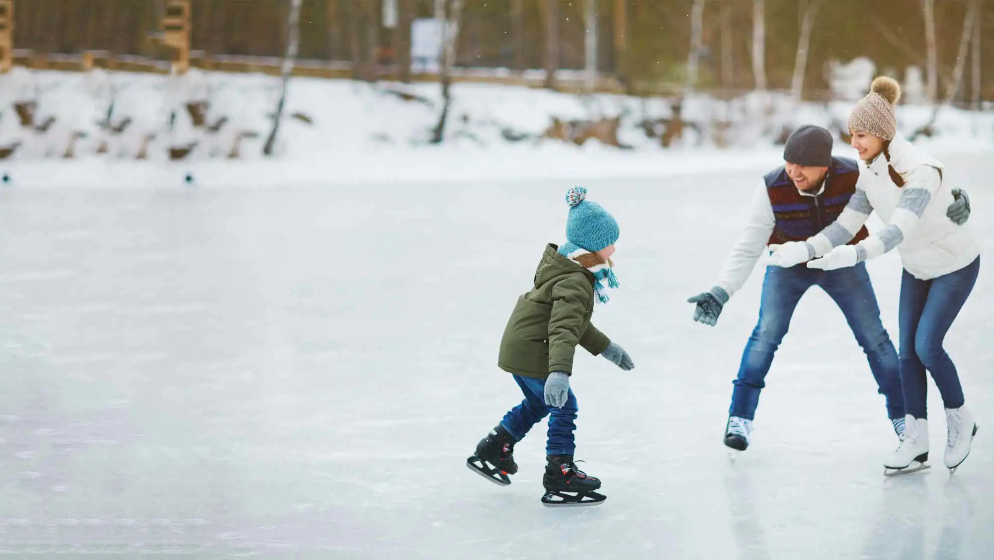 parents skating with their young daughter